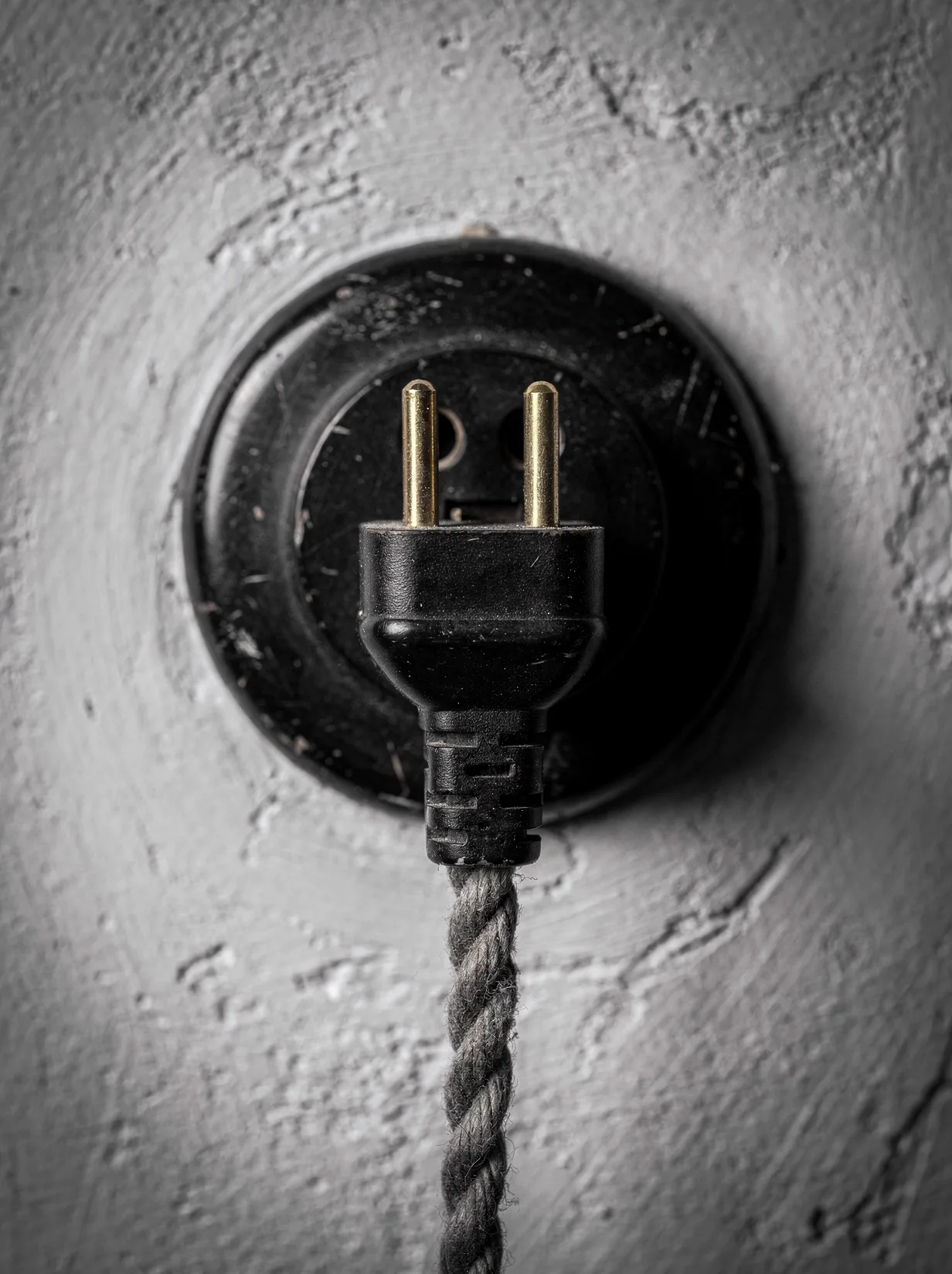 A vintage plug meeting its matching socket